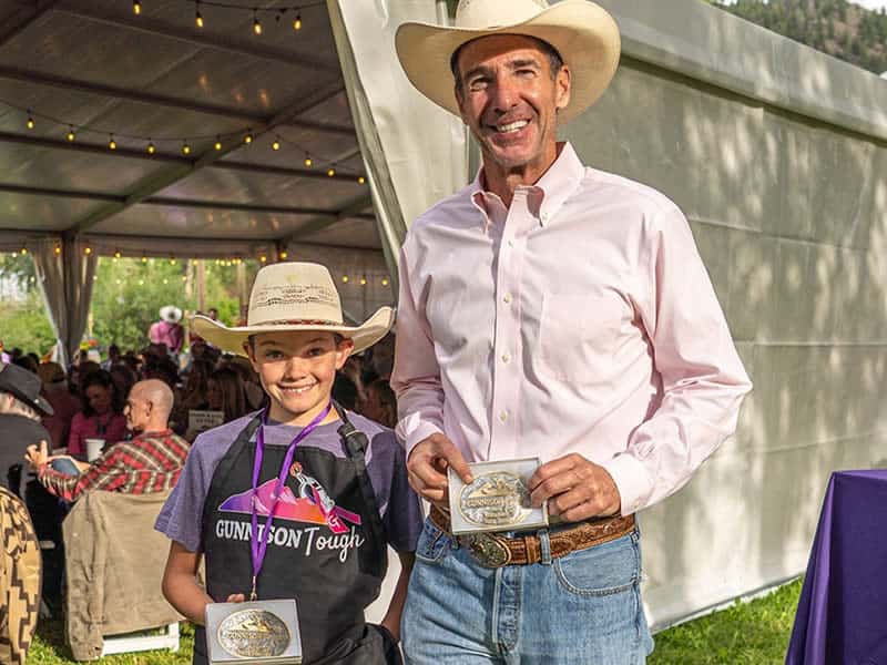 The winners of the GT 2024 Volunteers of the Year, Doug Dixon and Noah Mensing, proudly hold their buckles.